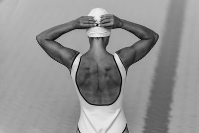 Rear view of woman in swimwear standing at swimming pool