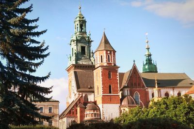 Low angle view of trees and buildings against sky