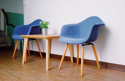 Empty chairs and table against wall at home