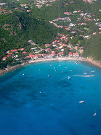 High angle view of sea by trees against blue sky