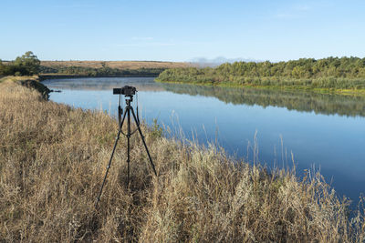 The camera on a tripod is installed on the river bank