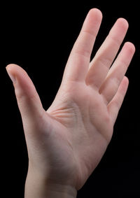 Close-up of human hand against black background