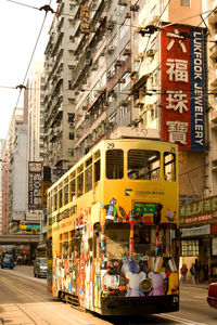 Train on street against buildings in city