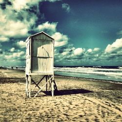 Scenic view of beach against cloudy sky