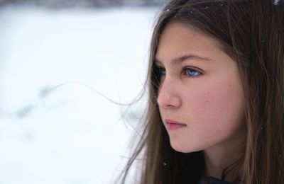 Close-up portrait of a beautiful young woman looking away