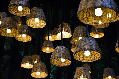 Low angle view of illuminated pendant lights hanging on ceiling