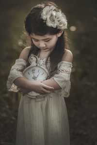 Close-up of girl holding clock