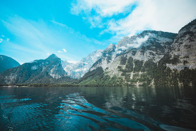 Scenic view of lake and mountains against blue sky