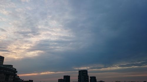 Low angle view of buildings against cloudy sky