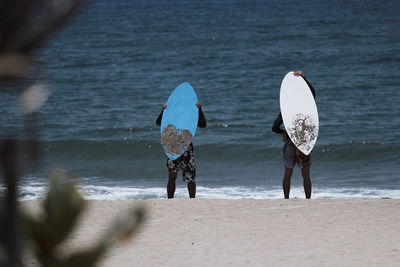 Rear view of people walking on beach