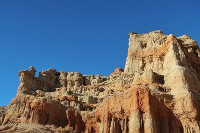 Low angle view of rock formations against blue sky