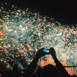 Man photographing fireworks from smart phone at night