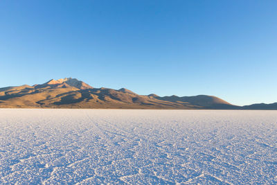 Scenic view of mountains against clear blue sky