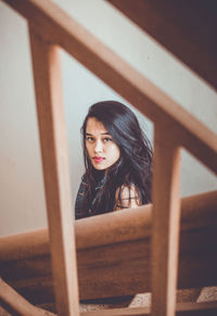 Portrait of beautiful young woman sitting on staircase