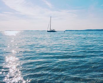 Sailboat sailing in sea against sky