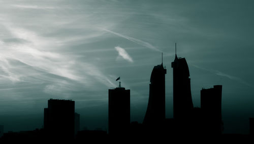 Low angle view of silhouette buildings against sky at dusk