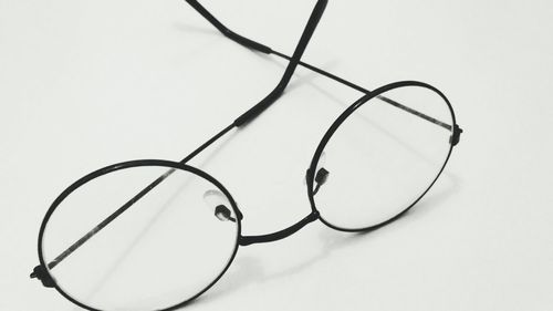 Close-up of eyeglasses on table against white background