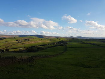 Idyllic shot of green landscape against sky