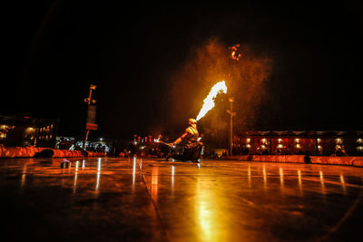 Fire-eater performing on stage against sky at night