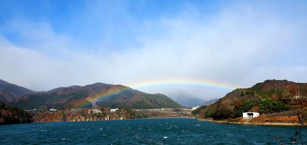 Scenic view of rainbow over sea against sky