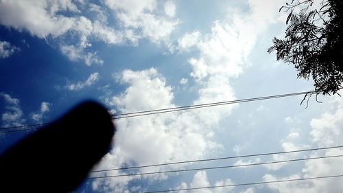 Low angle view of power lines against cloudy sky