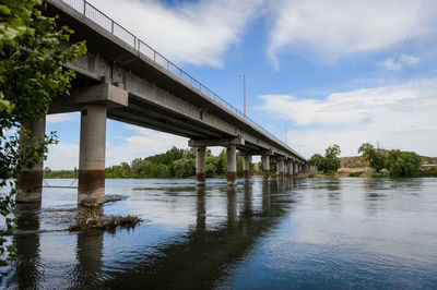 Low angle view of bridge over river against sky