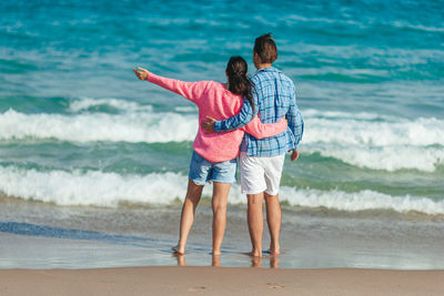 Side view of young woman standing at beach