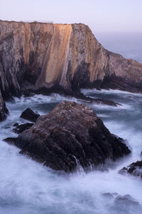 Scenic view of rocks in sea against sky