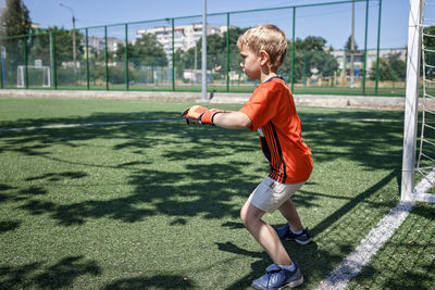 Side view of boy playing on grassland