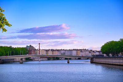 Bridge over river against cloudy sky