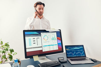 Analyst having business call on phone. businessman working with data on charts on computer in office