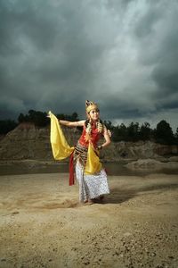 Rear view of woman standing dancer  at lake sky