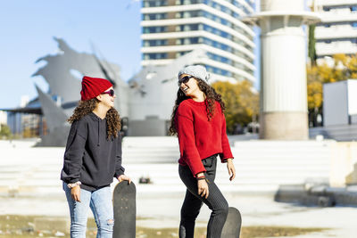 Full length of woman with umbrella in city