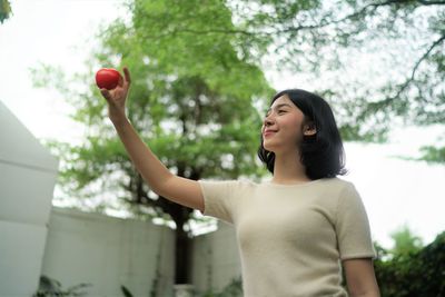 Teenage girl holding apple at yard