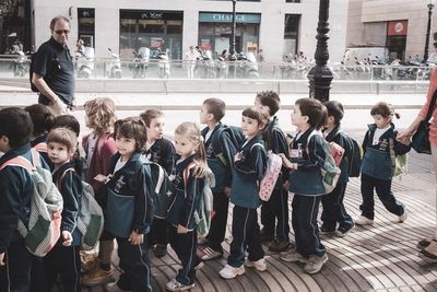 Group of people standing on street in city