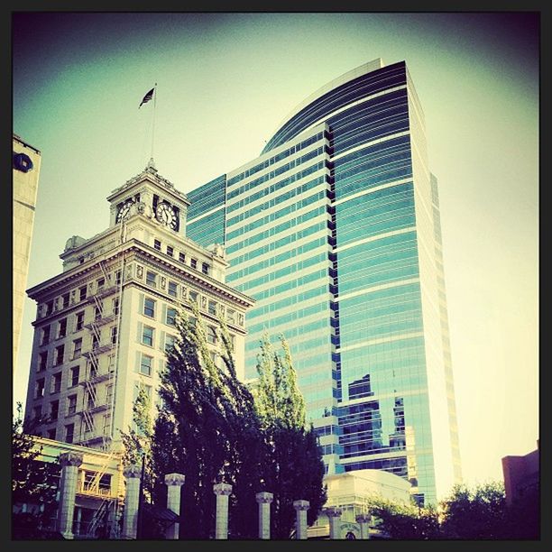 building exterior, architecture, transfer print, built structure, low angle view, auto post production filter, city, office building, skyscraper, modern, clear sky, tall - high, tower, building, glass - material, sky, window, day, tall, city life