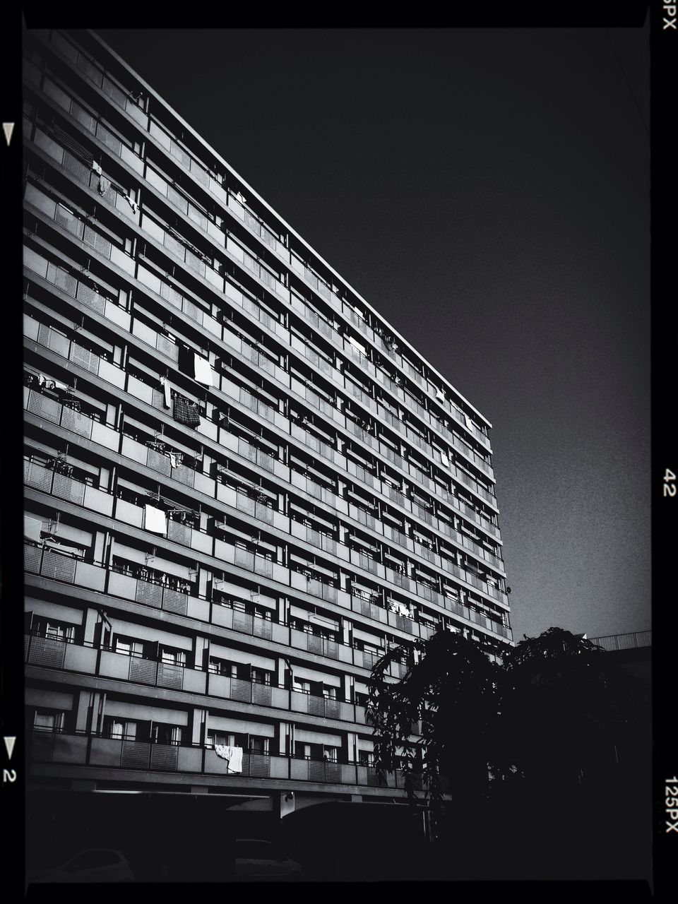 transfer print, building exterior, architecture, built structure, auto post production filter, city, clear sky, low angle view, building, car, transportation, modern, office building, city life, window, sky, day, skyscraper, outdoors, land vehicle