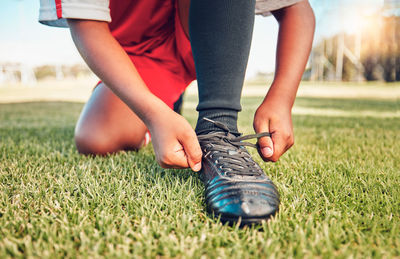 Low section of man tying shoelace