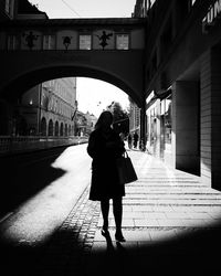 Rear view of women walking on footpath in city