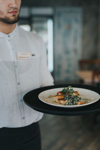 Midsection of man having food in restaurant