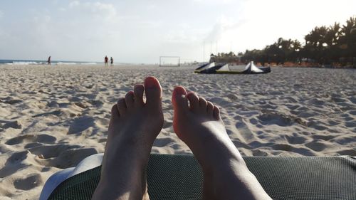 Low section of woman relaxing at beach