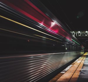 Light trails on illuminated bridge at night