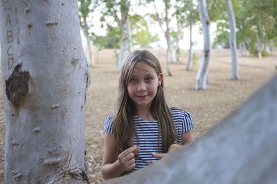 Portrait of smiling girl with mobile phone outdoors