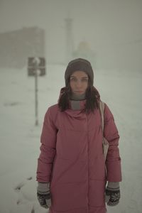 Portrait of young woman standing in snow