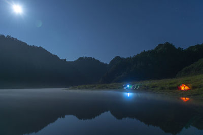 Scenic view of lake against sky at night