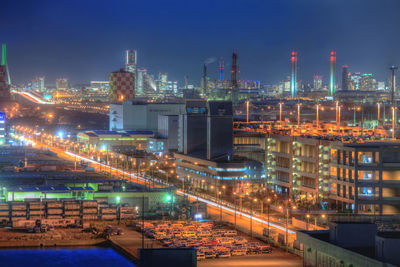 Illuminated factory against sky at night