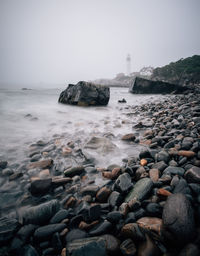 Rocks in sea against clear sky