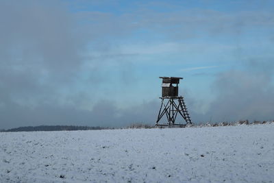 Lifeguard tower by sea against sky