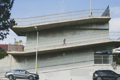 Low angle view of woman running on footbridge