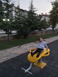 Boy sitting on yellow slide at playground